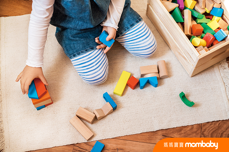 Little,Girl,Playing,With,Wooden,Bricks,At,Home.,She,Builds